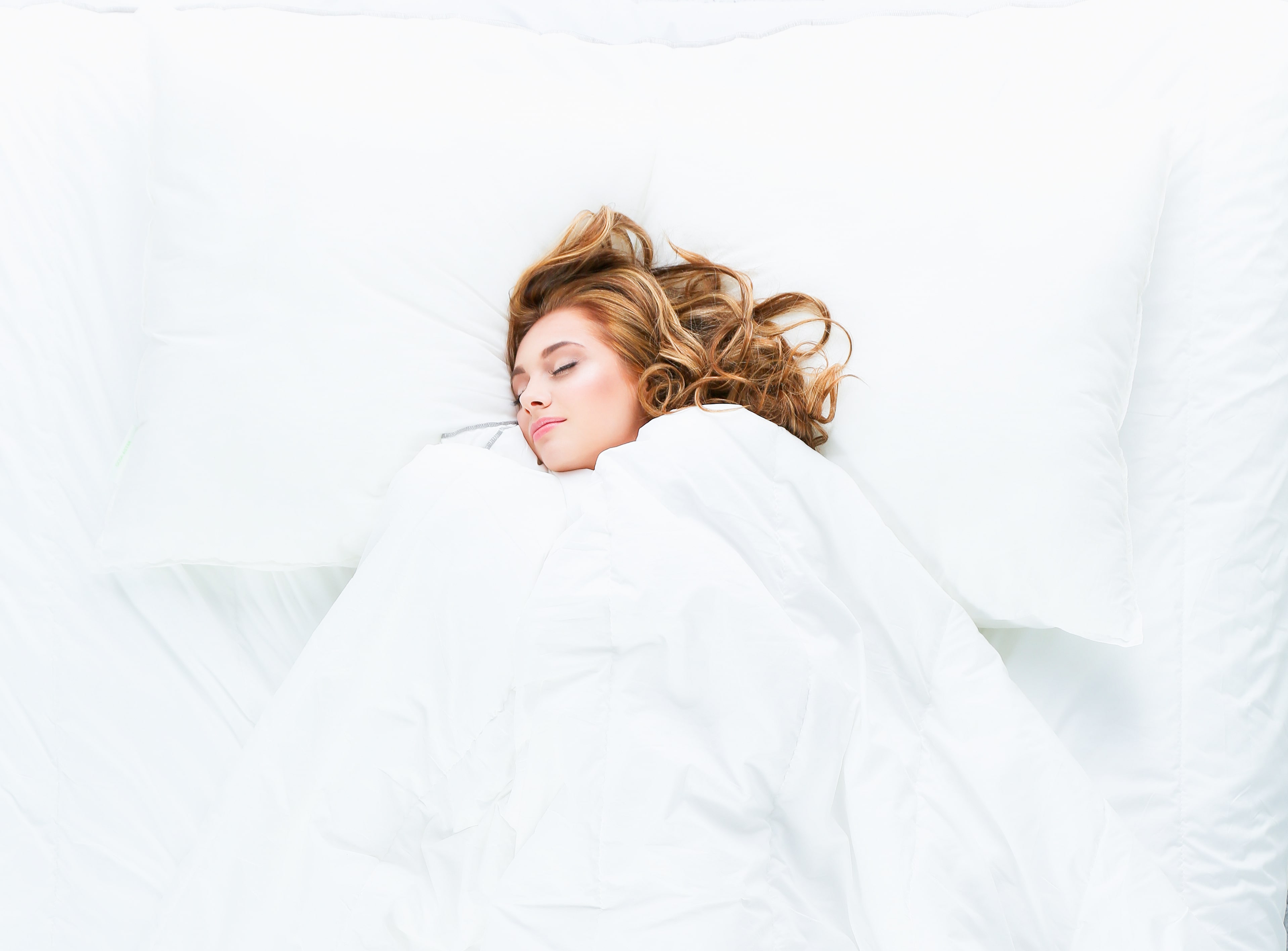 Femme dormant sous une couette de qualité douce et confortable