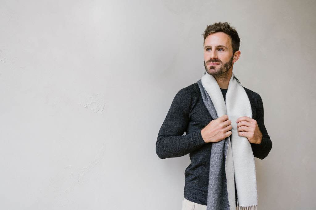 Man wearing a grey Baby Alpaca men’s wool scarf in an elegant winter outfit